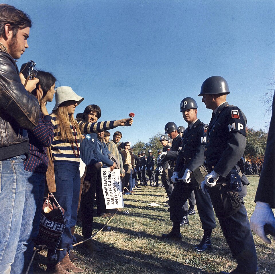 A female demonstrator offers a flower to military police on guard at the Pentagon during an anti-Vietnam demonstration. Arlington, Virginia, USA