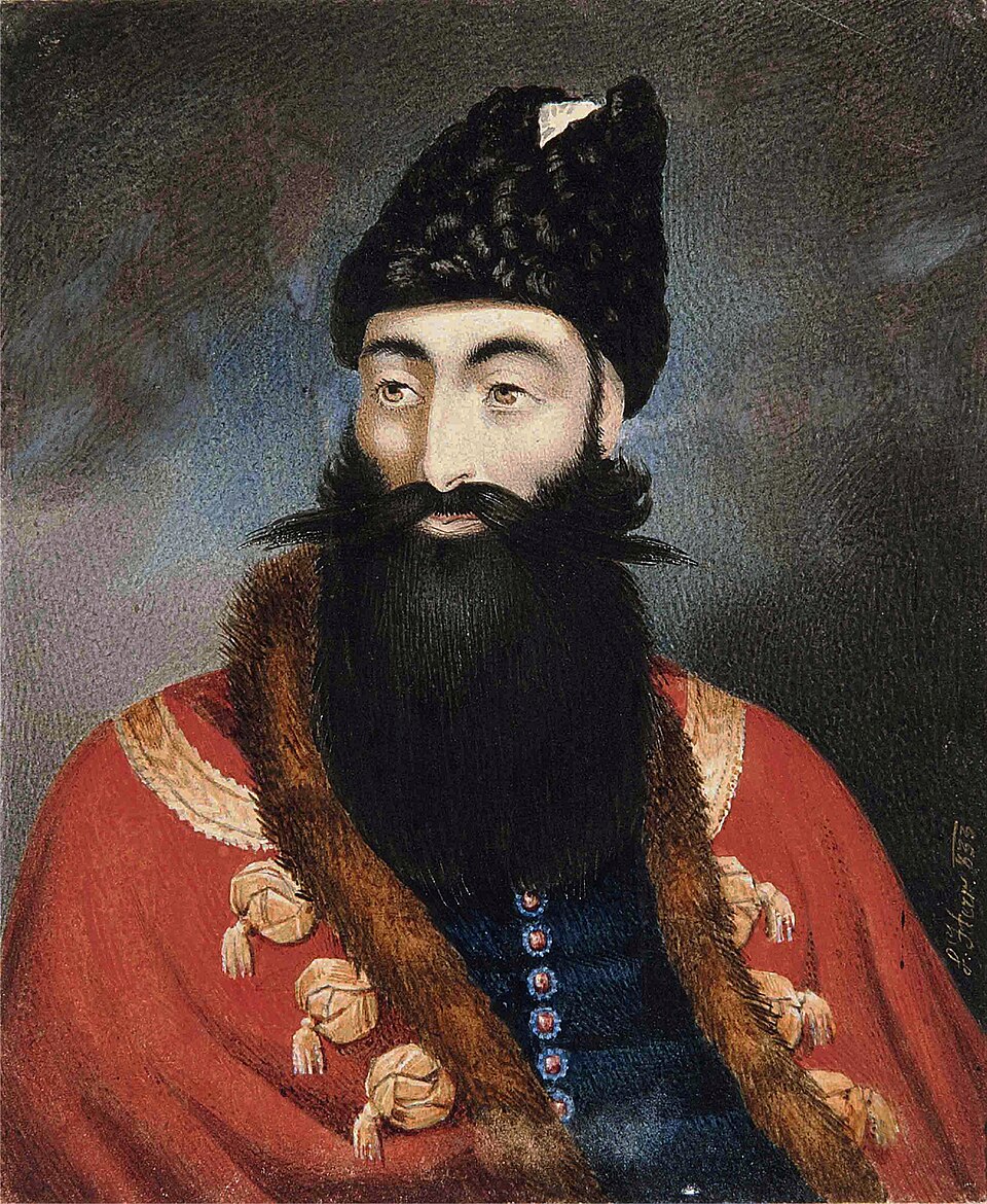 A PORTRAIT OF THE CROWN PRINCE 'ABBAS MIRZA SIGNED L. HERR, QAJAR IRAN, DATED (1)833 AD Watercolour on paper, depicted half length, wearing a red coat with…