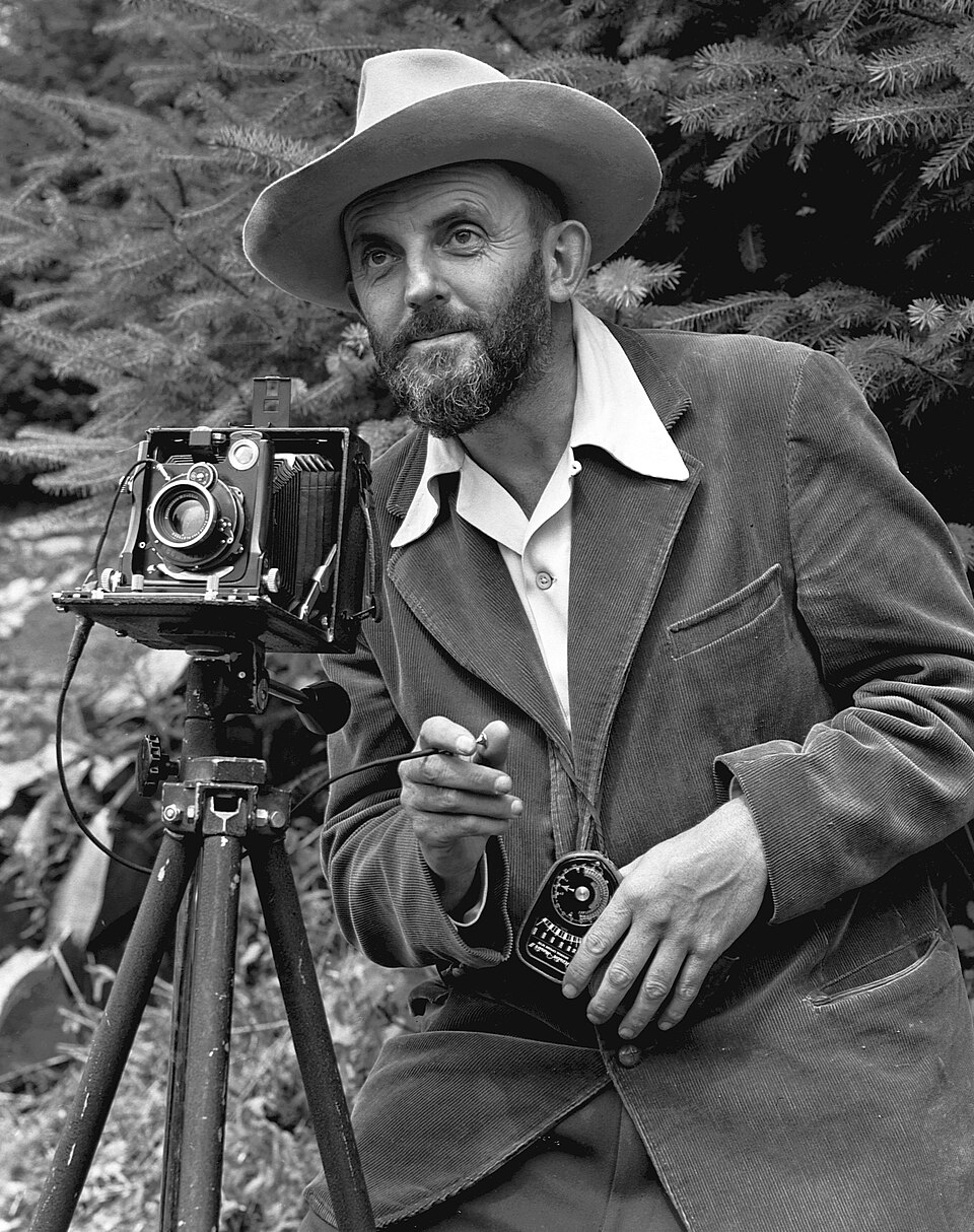 Photographic portrait of nature photographer Ansel Adams — which first appeared in the 1950 Yosemite Field School yearbook. The camera is probably a Zeiss…