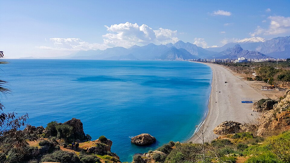 A view taken from the cliffs towards Antalya Konyaaltı Beach in February 2018. The snowy part in the middle is the Bey Mountains and the snowy mountain in…