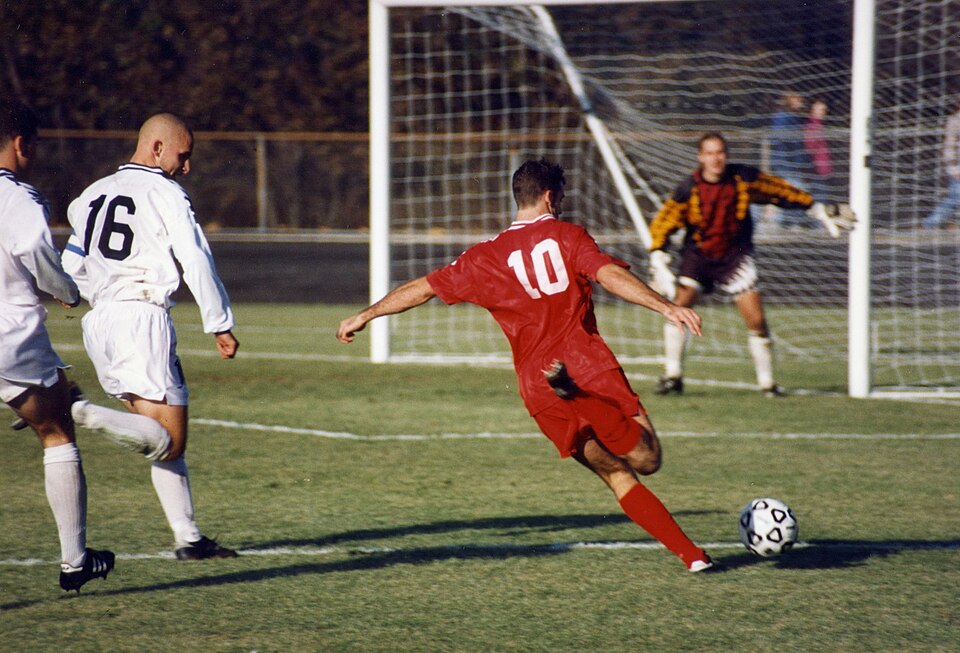 Association football (soccer) , Bloomington, Indiana. The offensive player (in red) is Chris Klein of the Indiana Hoosiers. He has sprinted past two…