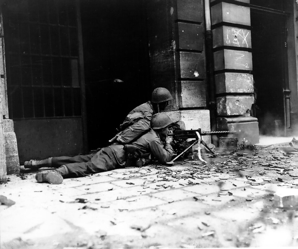 A GI machine gun crew (2d Battalion, 26th Infantry) with a M1919 Browning against the Nazi Wehrmacht in the streets of Aachen, Germany.