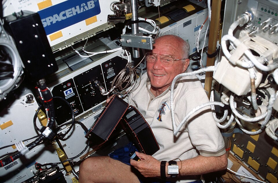 Oct. 1998 -- STS-95 payload specialist John Glenn removes the Advanced Organic Separation (ADSEP) cartridges and moves them to the Spacehab module. Photo…