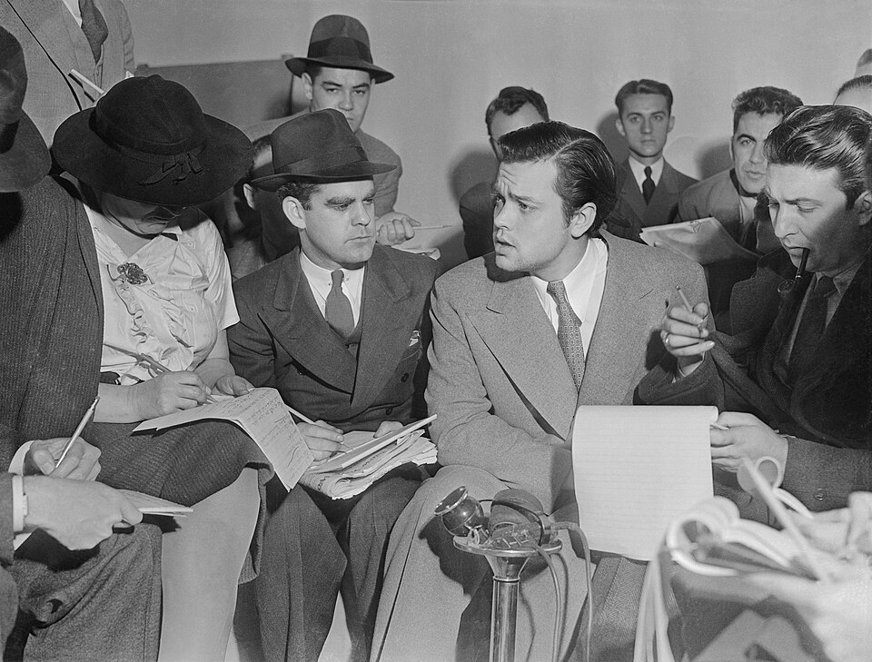 Photo of Orson Welles meeting with reporters in an effort to explain that no one connected with the War of the Worlds radio broadcast had any idea the show…