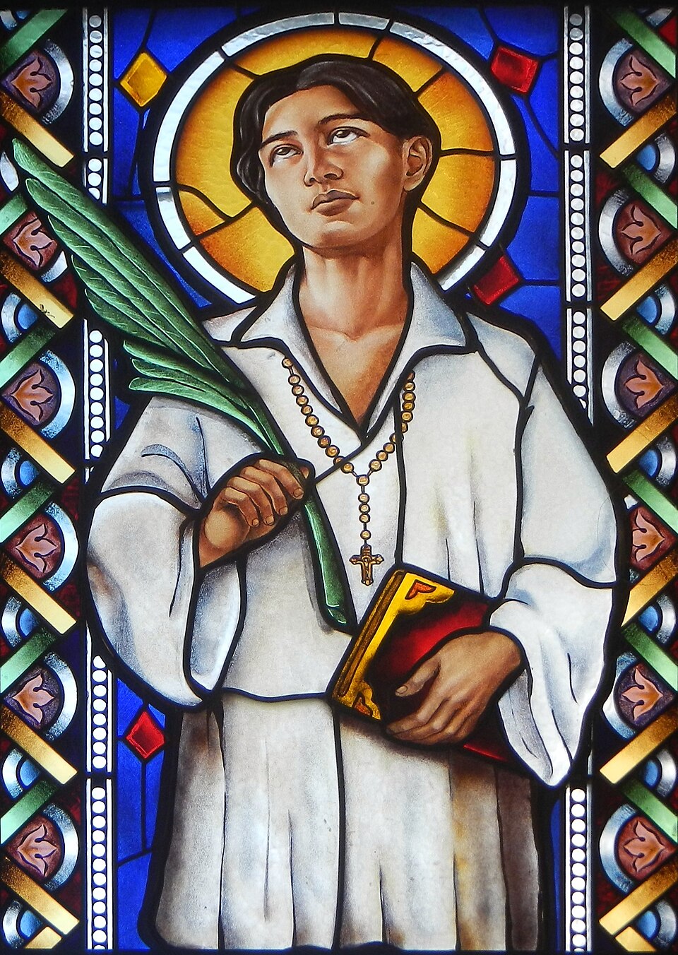 Image of Saint Pedro Calungsod on a stained glass window in Cubao Cathedral in 2016, holding on his right hand the Martyr's palm and on his left the…