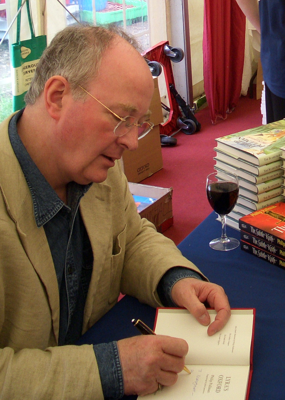 Philip Pullman signing a copy of Lyra's Oxford for a reader, Margaret Maitland , at the Oxford Literary Festival .