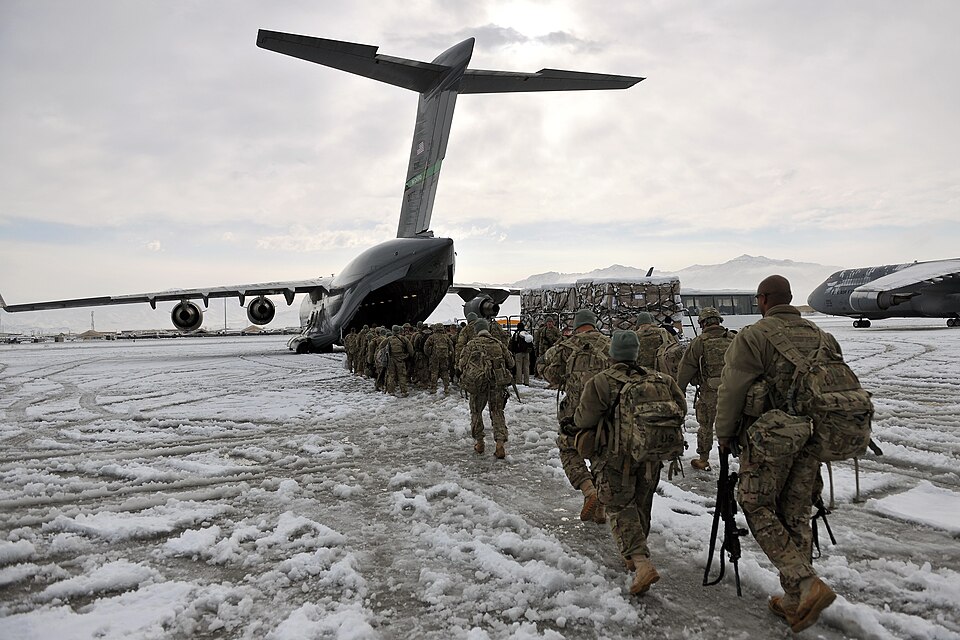 Service members board a U.S. Air Force C-17 Globemaster III at Bagram Air Field, Afghanistan, Dec. 28, 2012. The airfield management office coordinated snow…