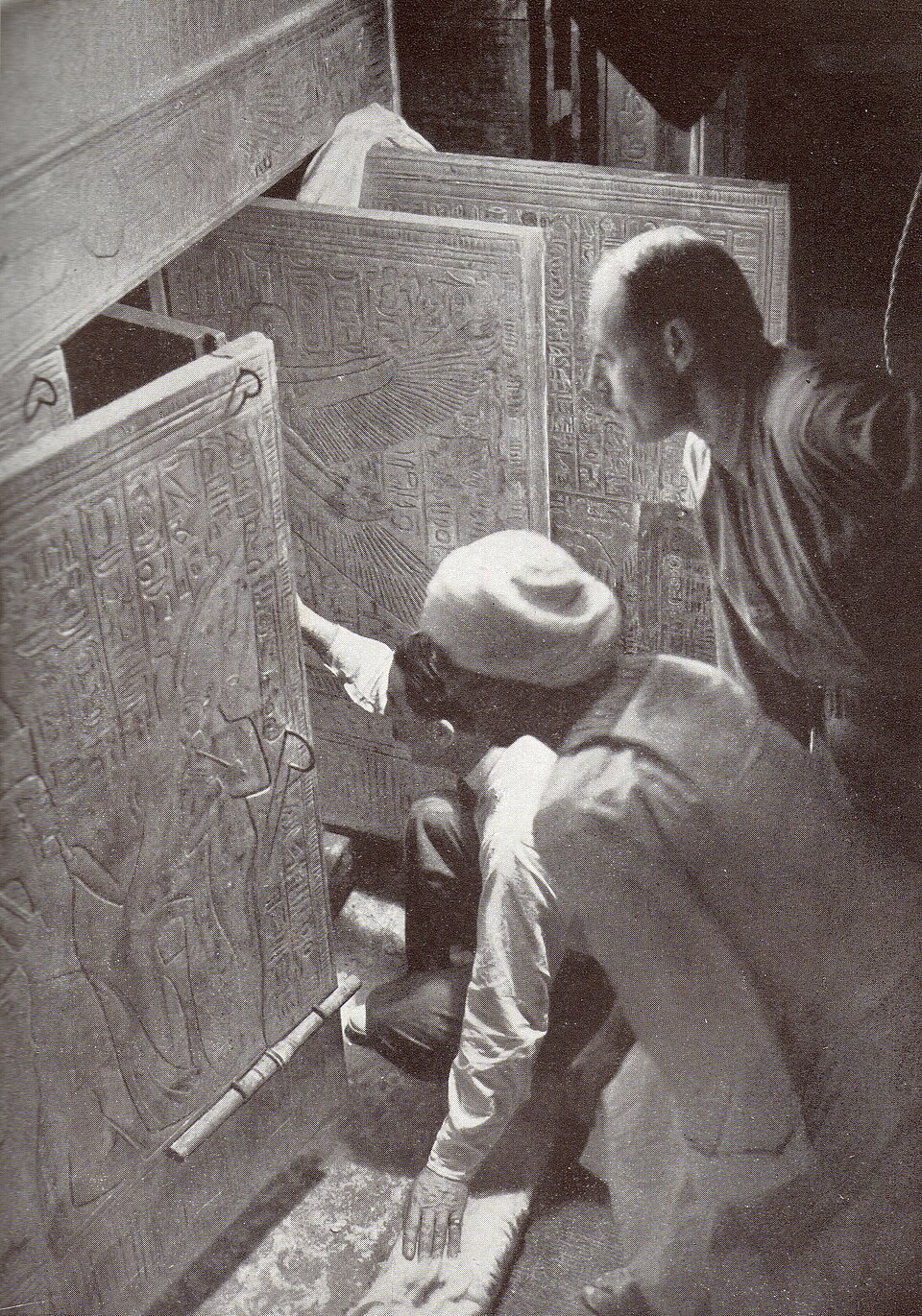 Howard Carter (kneeling), an Egyptian workman, and Arthur Callender at doors of burial shrines in Pharao Tutankhamen’s tomb .