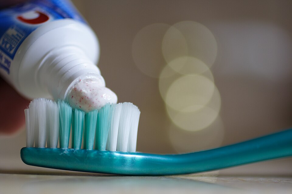 Putting toothpaste on a toothbrush. The toothpaste is Crest Pro-Health Clean Cinnamon, 0.454% stannous fluoride, 0.16% w/v fluoride ion.